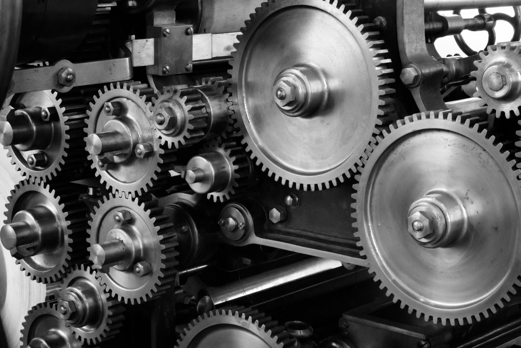gears-cogs-machine-machinery-159298-159298 Close-up view of a complex industrial gear mechanism in black and white.